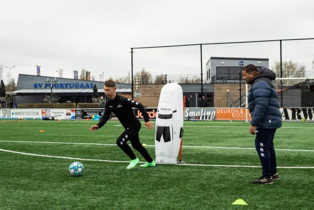 Leerling van voetbalschool voert oefening uit